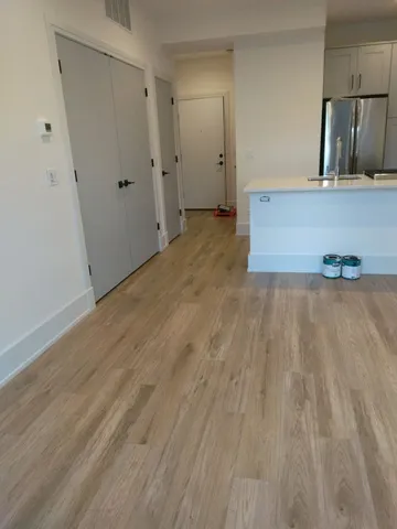 a view of a kitchen with wooden floor and cabinets