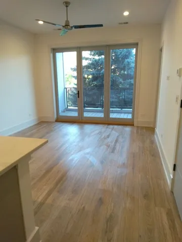 an empty room with wooden floor and outdoor view
