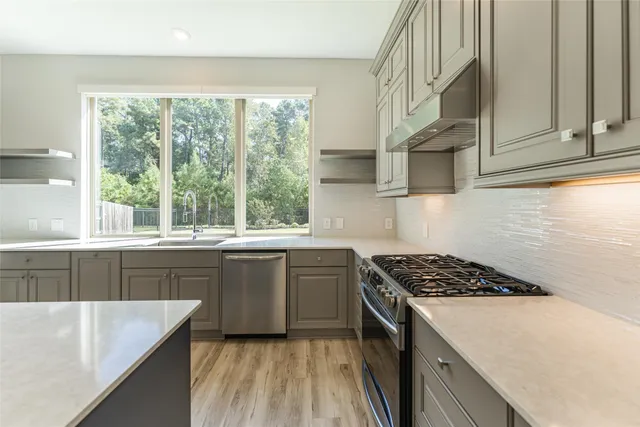 a kitchen with stainless steel appliances granite countertop a sink stove and cabinets