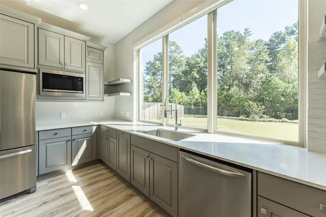 a kitchen with stainless steel appliances cabinets a large window and a sink