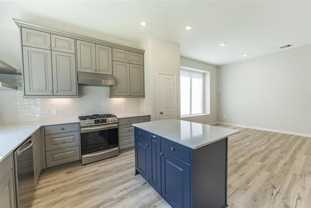 a kitchen with granite countertop a sink stove and cabinets