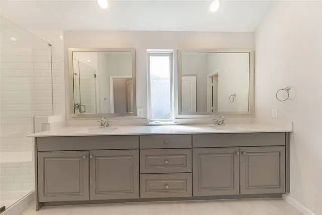a bathroom with double sink and a mirror