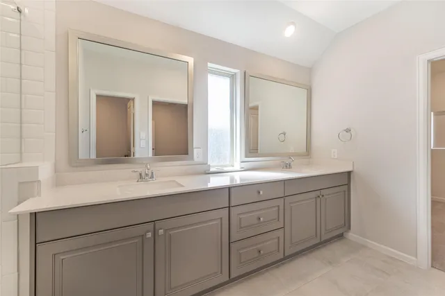 a bathroom with double sink and a mirror