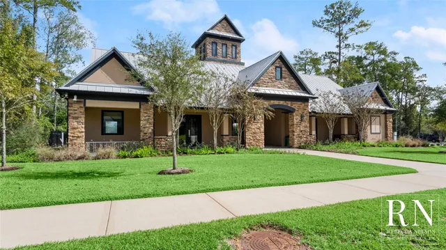 a front view of a house with a yard and trees