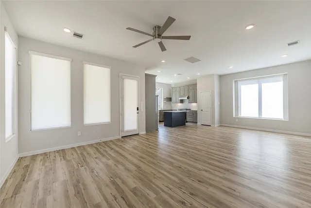 a view of empty room with wooden floor and window