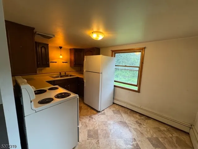 a kitchen with refrigerator and white cabinets
