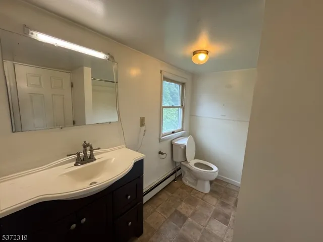 a bathroom with a sink toilet and a mirror
