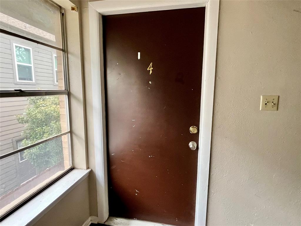 Clean entryway with a solid wood-tone door and nearby window for natural light.