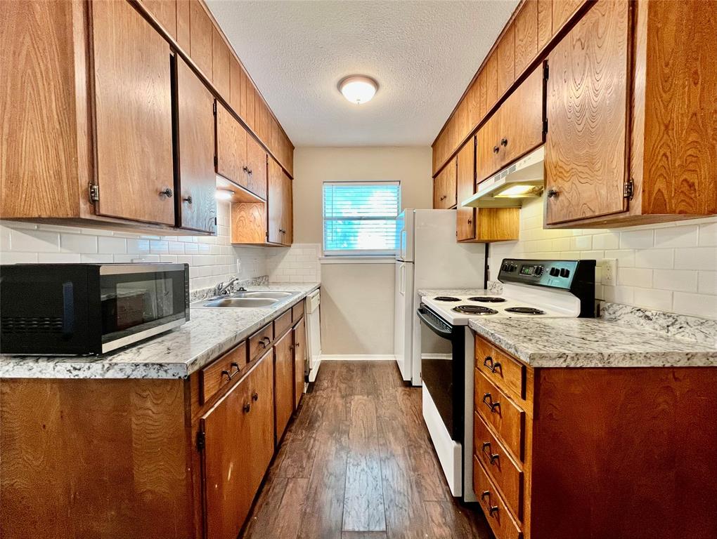 1107 North Locust Street, Unit 4 Denton, TX 76201 - Photo 4 of 8 Functional galley kitchen with plenty of counter space and standard appliances.