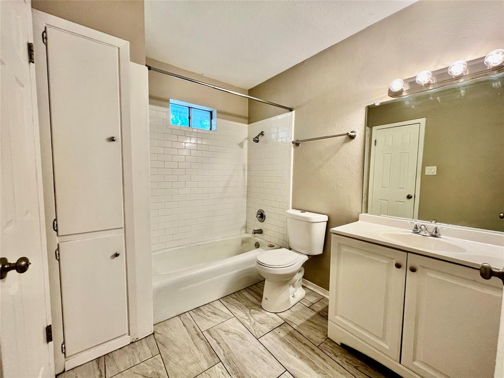 1107 North Locust Street, Unit 4 Denton, TX 76201 - Photo 6 of 8 Full bathroom with a large vanity, wide mirror, and built-in storage.