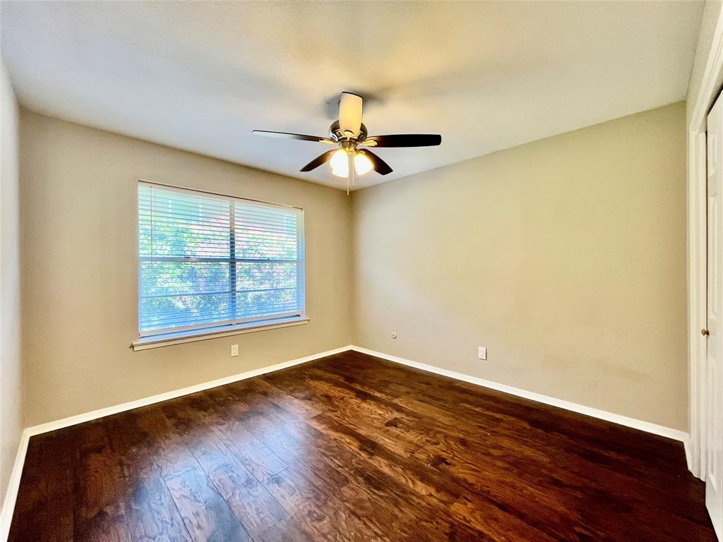 1107 North Locust Street, Unit 4 Denton, TX 76201 - Photo 8 of 8 Comfortable secondary bedroom with a ceiling fan and a large, bright window