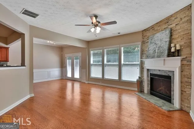 a view of an empty room with a fireplace and a window