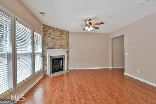 a view of empty room with a fireplace and wooden floor