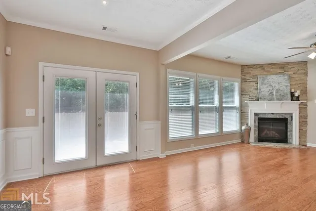 a view of an empty room with a window and fireplace