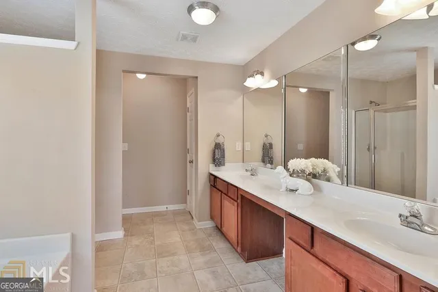 a bathroom with a double vanity sink mirror and shower