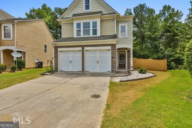 a view of a house with pool and a yard