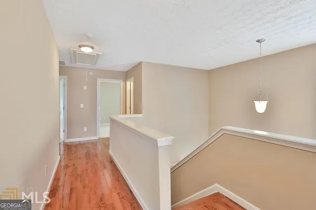 a view of a hallway with wooden floor