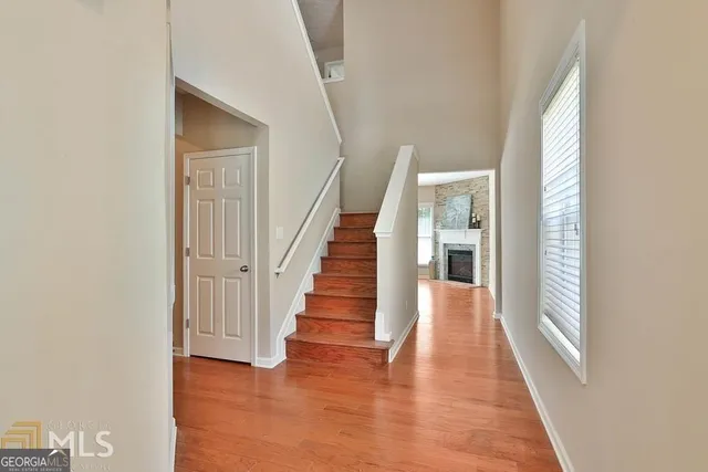 a view of a hallway with wooden floor and staircase