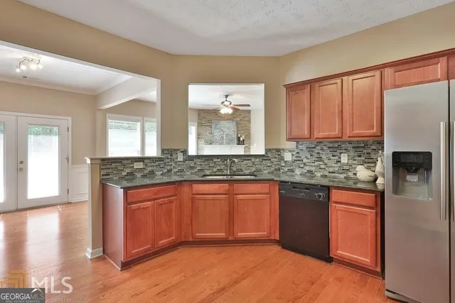 a kitchen with stainless steel appliances granite countertop a stove a sink dishwasher and a refrigerator