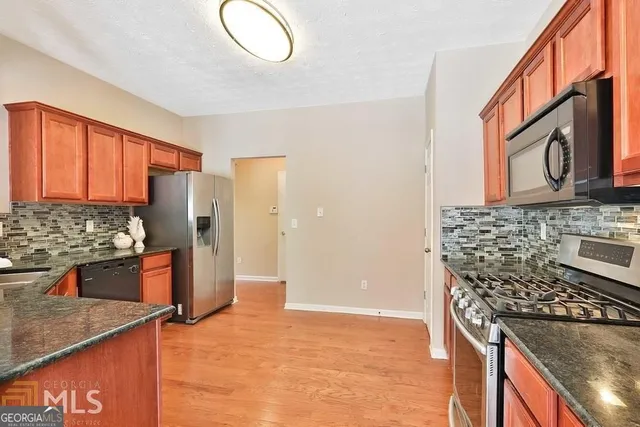 a kitchen with stainless steel appliances granite countertop a stove a refrigerator and a microwave