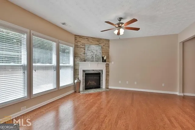a view of an empty room with window and fire place