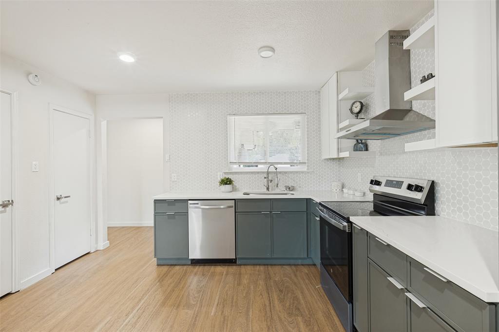 1215 Fordham Road Dallas, TX 75216 - Photo 7 of 25 Contemporary kitchen featuring wood-finish flooring, white solid surface countertops, and a hexagonal tile backsplash