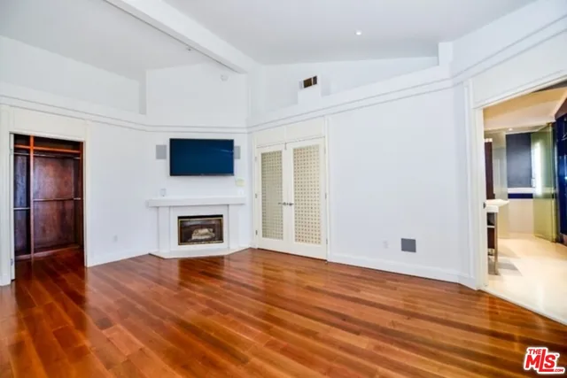 a view of a livingroom with wooden floor and a fireplace