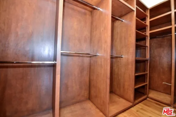 a view of walk in closet with empty racks