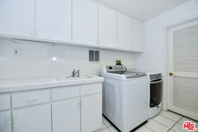 a utility room with cabinets washer and dryer