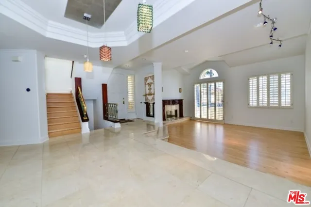 an empty room with fireplace and windows