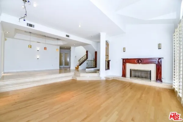 a view of a livingroom with a fireplace a ceiling fan and fire place