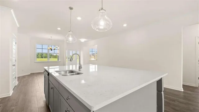 a kitchen with a sink chandelier and wooden floor