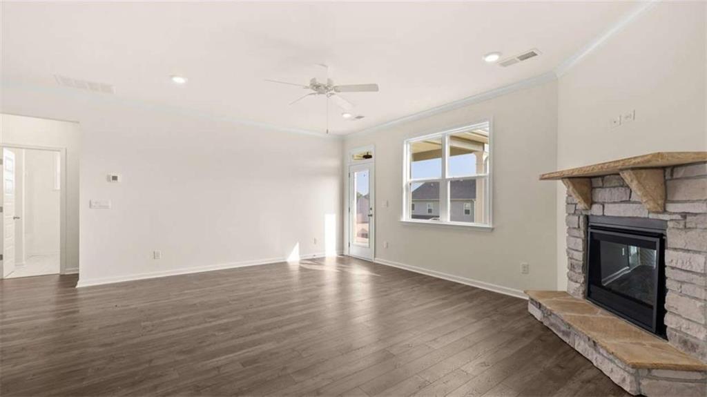 1812 Quaker Street Hampton, GA 30228 - Photo 23 of 53 an empty room with wooden floor a ceiling fan and windows