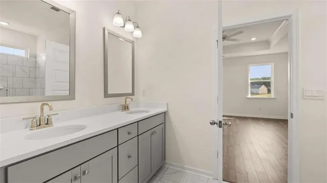 a view of a hallway with wooden floor and a bathroom