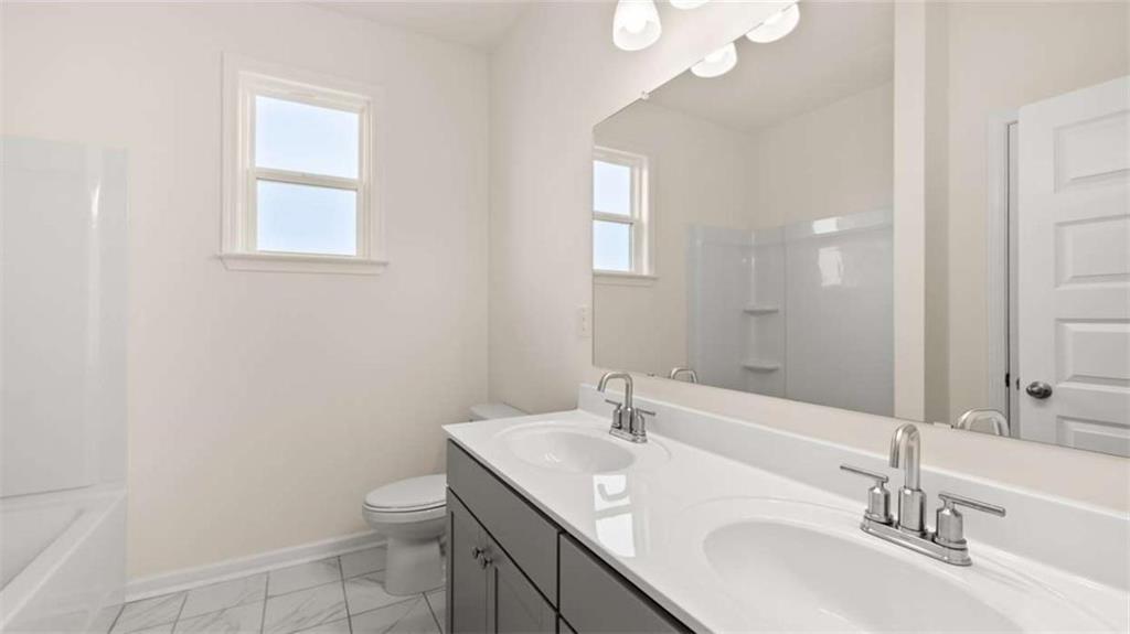 1812 Quaker Street Hampton, GA 30228 - Photo 39 of 53 a bathroom with a sink a toilet and a mirror