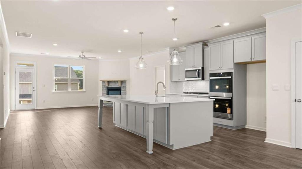 1812 Quaker Street Hampton, GA 30228 - Photo 10 of 53 a large kitchen with stainless steel appliances kitchen island a large counter top and wooden floors