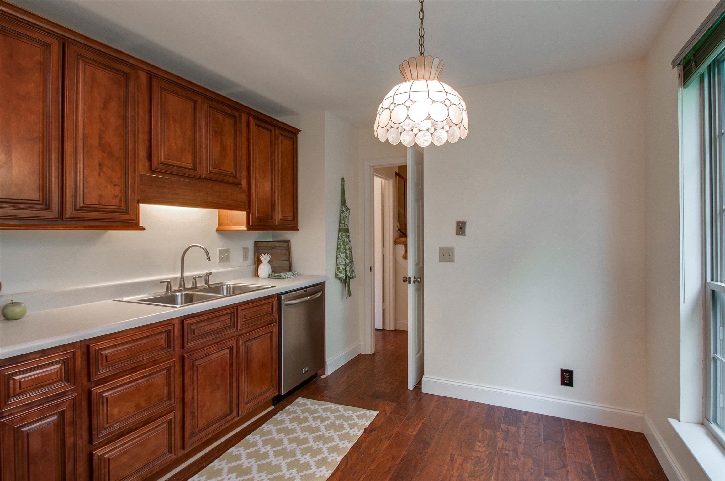 850 General George Patton Road, Unit 850 Nashville, TN 37221 - Photo 12 of 25 a kitchen with a sink a refrigerator cabinets and wooden floor