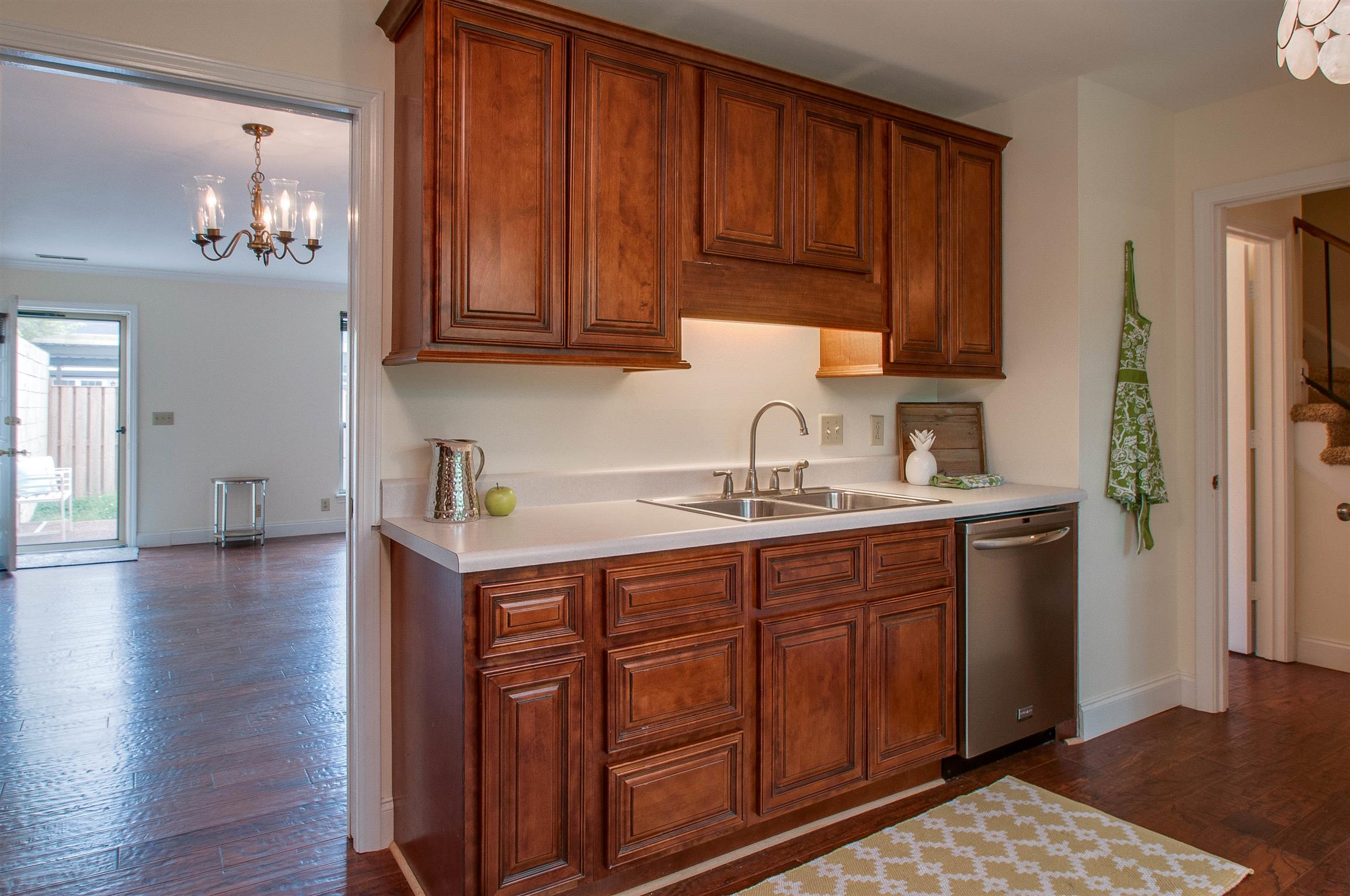 850 General George Patton Road, Unit 850 Nashville, TN 37221 - Photo 13 of 25 a kitchen with stainless steel appliances granite countertop a refrigerator a sink dishwasher and wooden cabinets with wooden floor