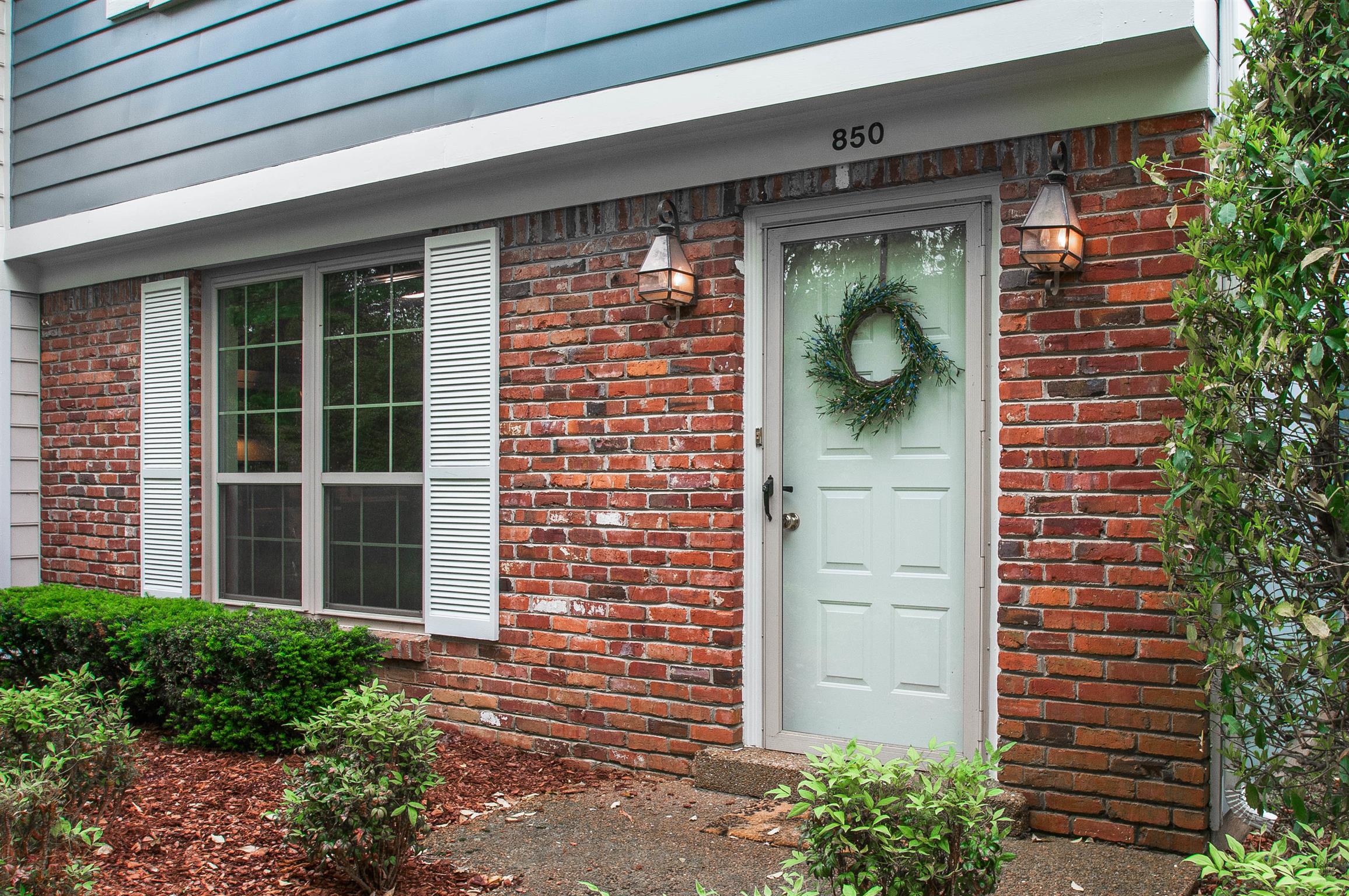 850 General George Patton Road, Unit 850 Nashville, TN 37221 - Photo 3 of 25 a front view of a house with a large window and potted plants