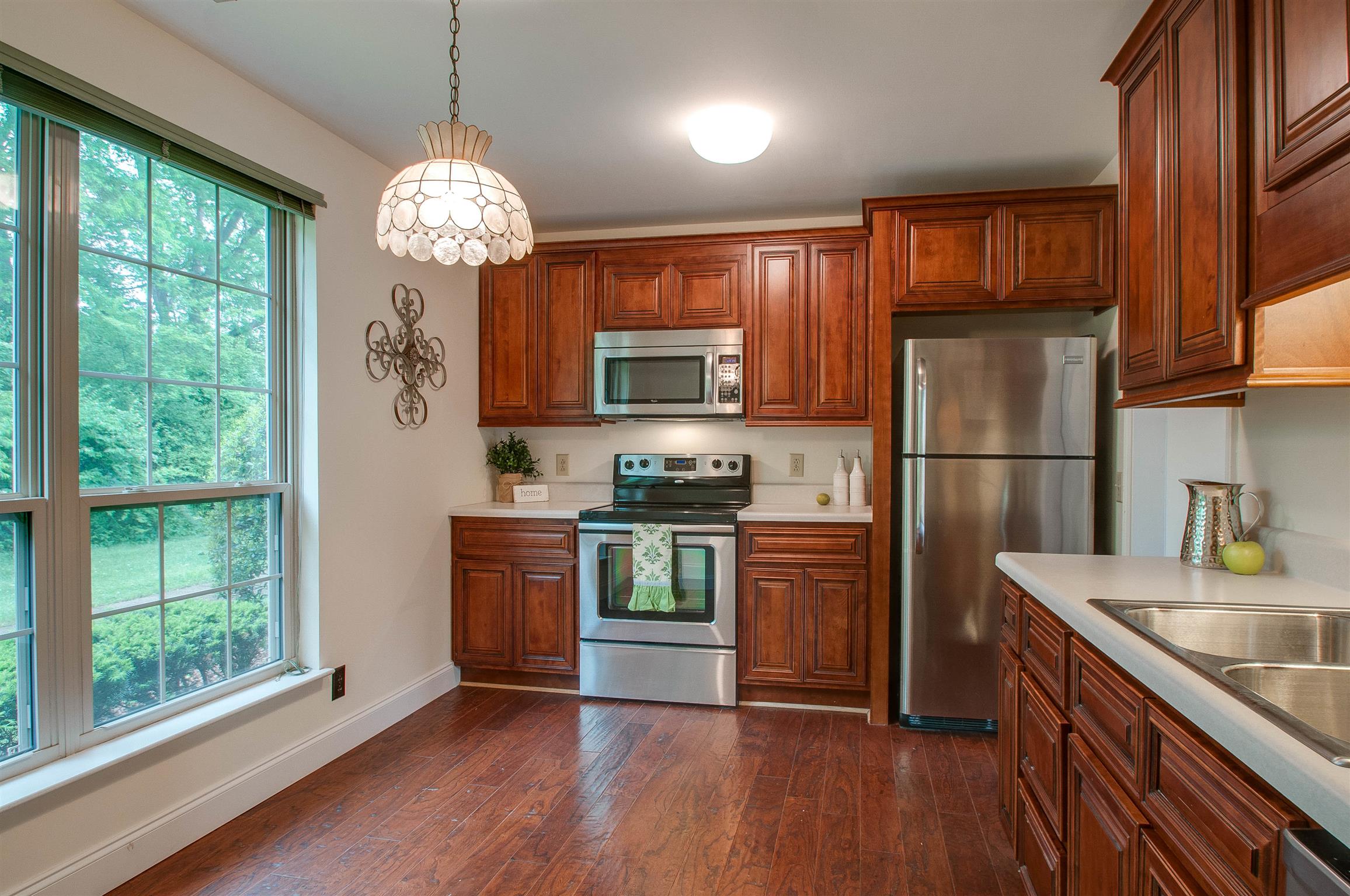 850 General George Patton Road, Unit 850 Nashville, TN 37221 - Photo 10 of 25 a kitchen with stainless steel appliances granite countertop a refrigerator a sink dishwasher a stove and white cabinets with wooden floor