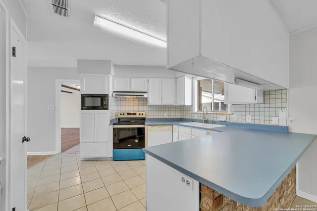 a kitchen with stainless steel appliances a stove sink microwave and cabinets