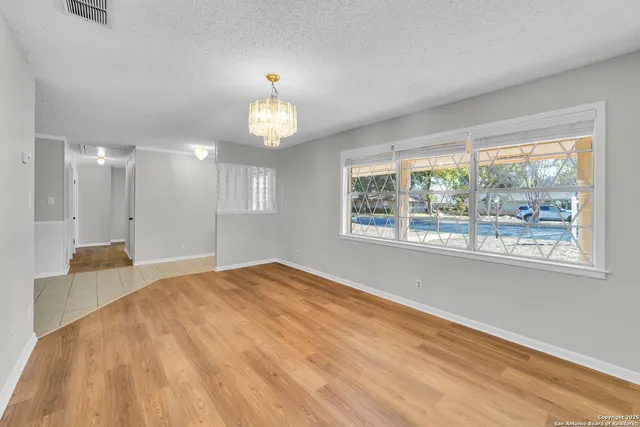 a view of empty room with wooden floor and window