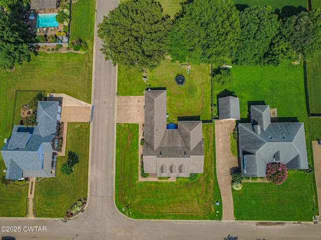an aerial view of a house with outdoor space lake view and trees in the background