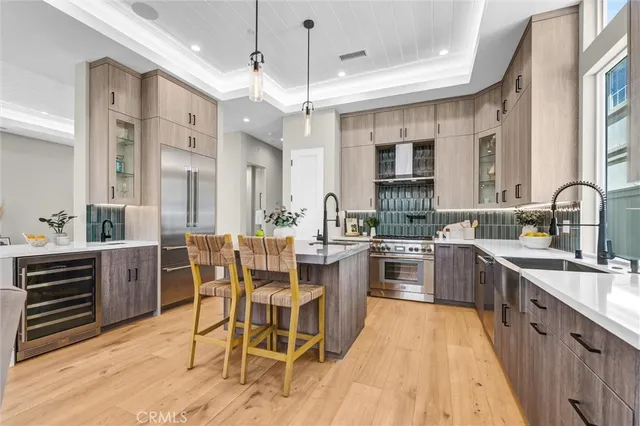 a view of a dining room and livingroom with furniture wooden floor a chandelier