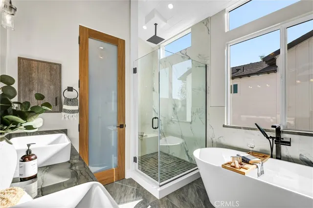 a bathroom with a tub a sink and glass door