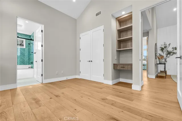 a view of empty room with wooden floor and windows