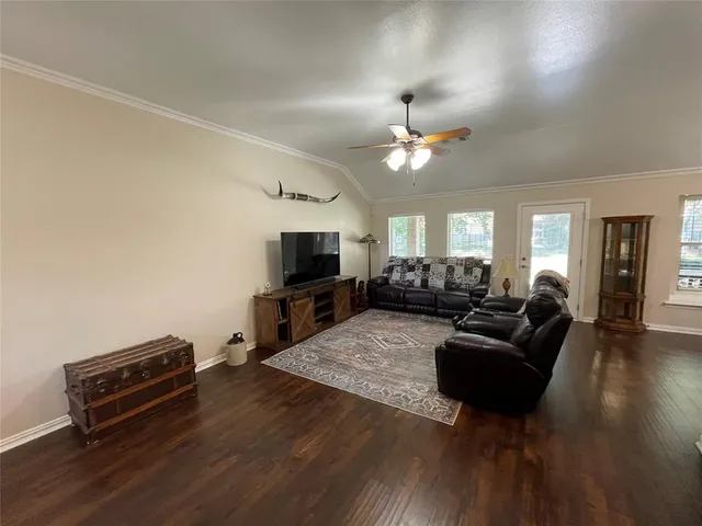 a living room with furniture a ceiling fan and a flat screen tv