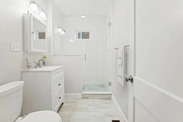 a bathroom with a sink a toilet and shower