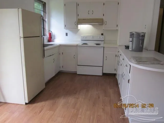 a kitchen with a sink a refrigerator and cabinets