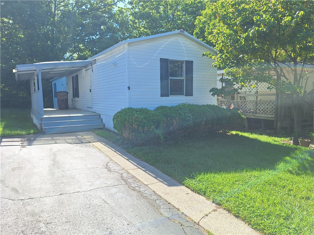9500 Collett Road, Unit 9 Waynesville, OH 45068 - Photo 1 of 2 This charming home offers a cozy retreat with a welcoming porch and lush greenery.